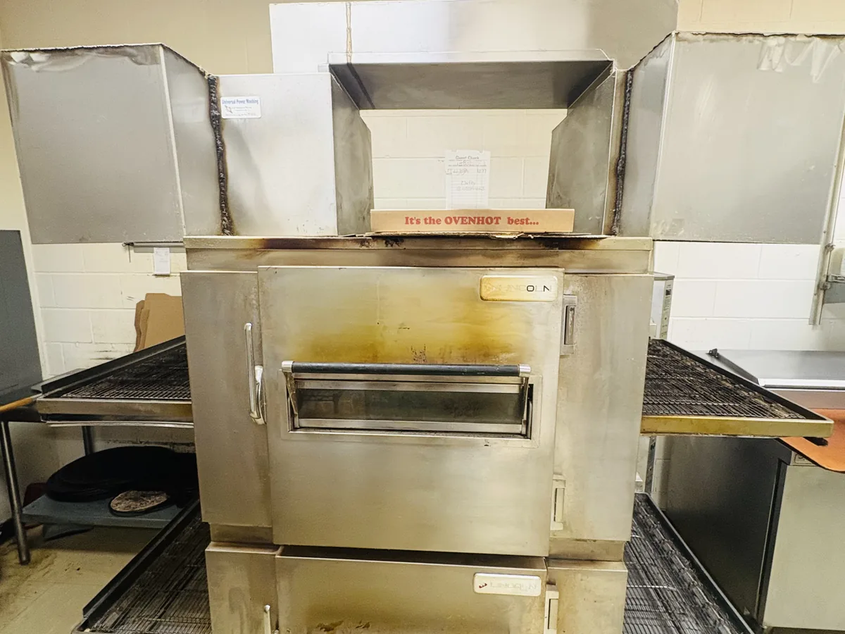 Conveyor pizza oven with heavy grease staining before cleaning