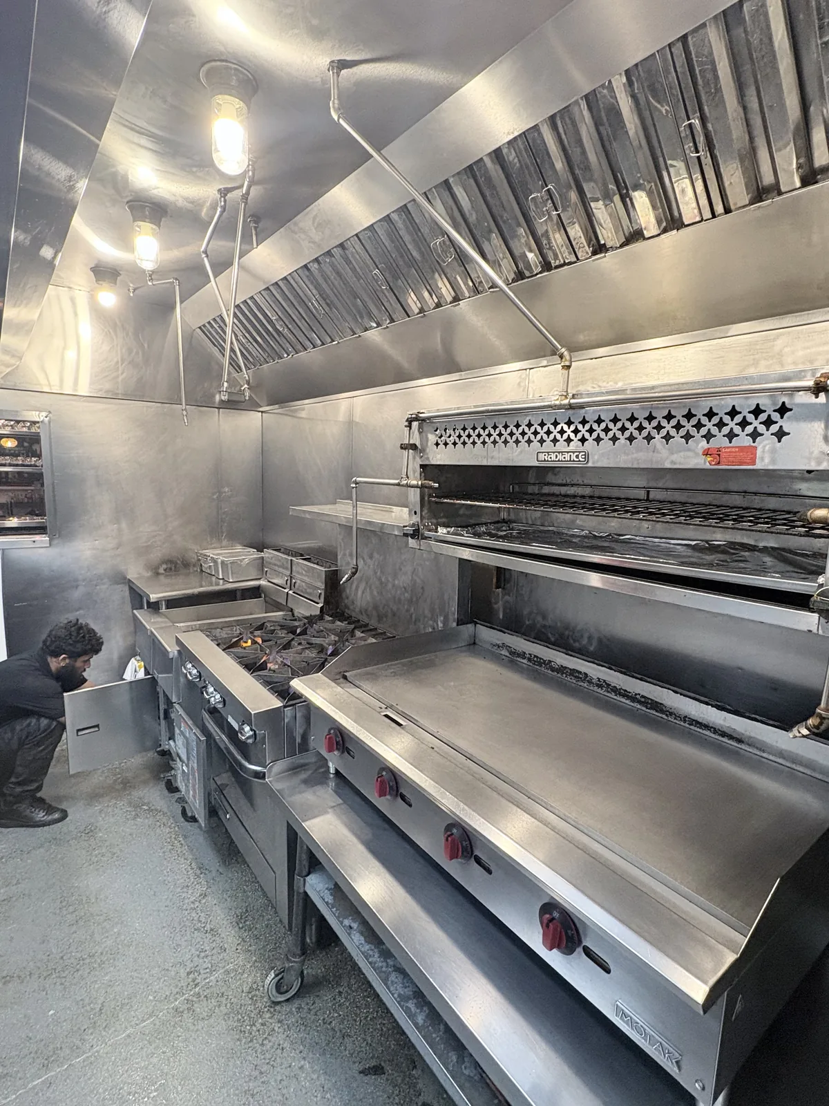 Spotless commercial kitchen cook line and stainless exhaust hood after a full ARC hood and equipment cleaning